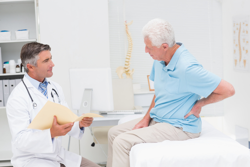 Person discussing back pain with doctor