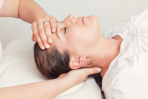 Woman having osteopathic treatment for headache