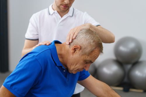 Therapist examining man's neck