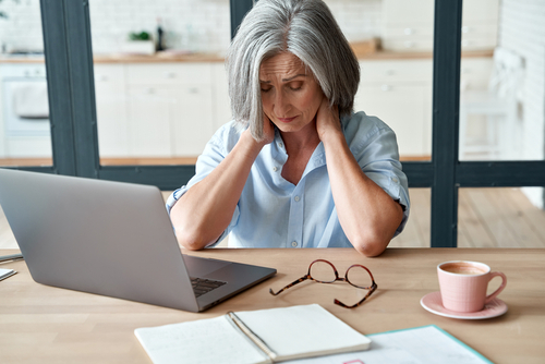 Woman at desk suffering from chronic pain