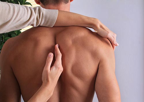 Man being treated for back pain by osteopath