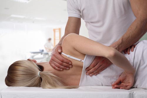 Woman being treated for back pain by osteopath